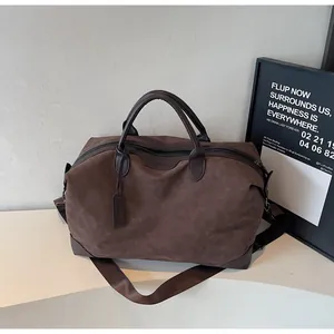 Large brown suede travel bag with top handles and a detachable shoulder strap