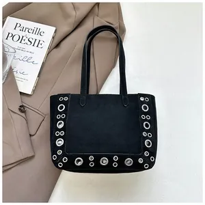 Gros plan d'un sac cabas vintage en daim noir avec de grands œillets décoratifs