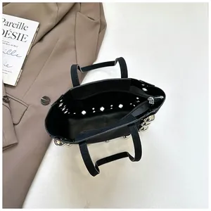 Vue détaillée d'un sac cabas noir en daim à clous avec poche intérieure zippée