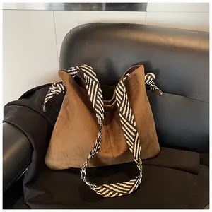 Vintage brown suede tote bag with a striking black and white striped shoulder strap