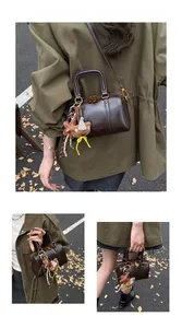 Minimalist dark brown Boston bag with double zippers and cute hanging charms.