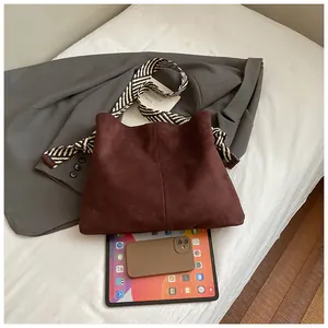 Detail of vintage suede tote bag shown with a tablet for size comparison purpose