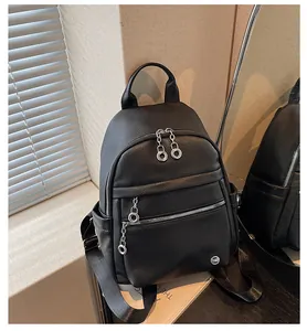 Detailed view of a high-quality black pebbled leather backpack with circular zipper pulls