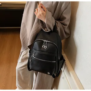 Detail view of stylish black textured leather backpack for women with multi-pocket design