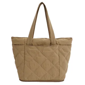 Detaillierte Vorderansicht einer khakifarbenen Stepptasche mit elegantem Rautenmuster.
