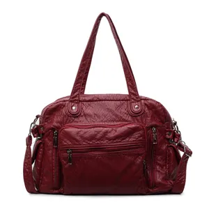 Front detail of a vintage wine red PU leather tote bag with multiple zip pockets.