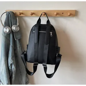 Detail of black vintage women's backpack with adjustable straps and multiple pockets