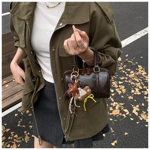 Minimalist coffee brown mini Boston handbag with star and bear charms in outdoor setting