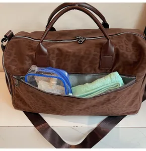 Dettaglio della grande borsa da viaggio leopardata marrone con la tasca frontale