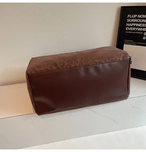 Dettaglio di una borsa da viaggio grande con stampa leopardata e similpelle marrone