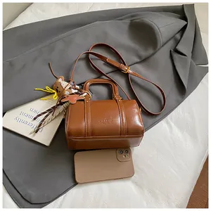Elegant vintage brown leather Boston bag with teddy charm and top handle for women