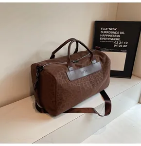 Vista dettagliata dell'elegante borsa da viaggio leopardata marrone con logo in pelle