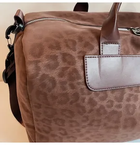 Primo piano della trama maculata marrone su una borsa da viaggio grande ed elegante