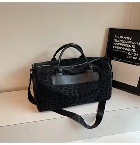 Vista dettagliata della borsa da viaggio leopardata nera su marmo bianco