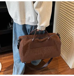 Grande borsa da viaggio marrone con stampa leopardata portata da una persona in un interno