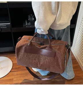 Vista dettagliata della grande borsa da viaggio leopardata con dettagli in pelle marrone