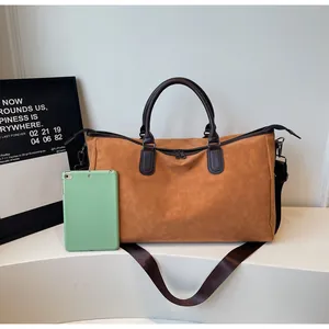 Sac de voyage beige spacieux posé à côté d'une tablette pour montrer sa capacité