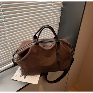 Large brown suede travel bag with dual handles and crossbody strap for short trips