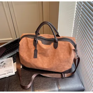 Minimalist large brown travel tote bag with adjustable shoulder strap in a lifestyle setting.
