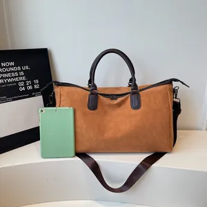 Sac de voyage marron imperméable avec poignées sombres et tablette verte pour référence.
