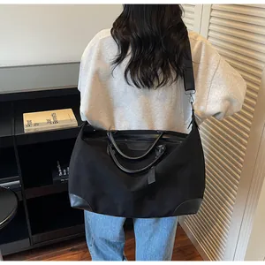 Large capacity black travel tote bag with leather trim and adjustable shoulder strap