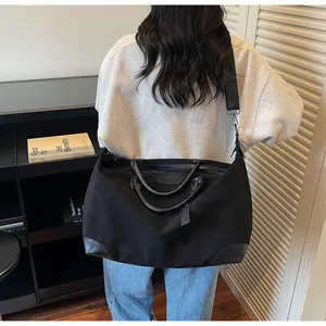 Large black travel tote bag for women shown from a stylish back-carrying perspective