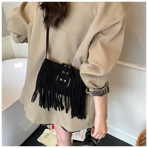 Chic black suede fringe saddle bag detail, vintage Maillard style retro fashion accessory.