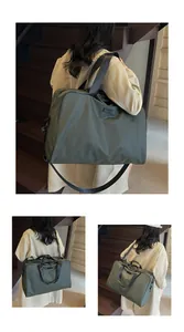 Detail view of a large olive green travel duffel bag carried by a model on stairs