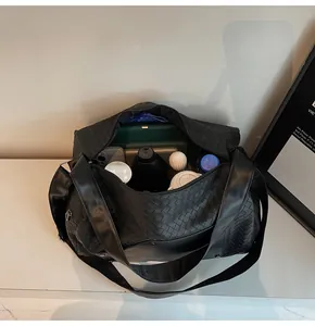 Vista interna di una borsa da fitness nera intrecciata che mostra la grande capacità.