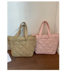 Zwei gesteppte Tragetaschen in Khaki und Rosa mit minimalistischem Rautenmuster-Design.
