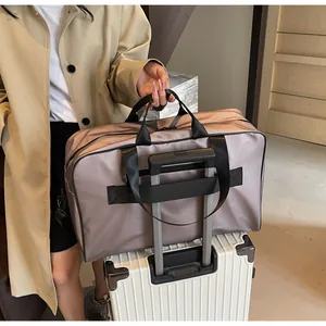 Details of a large capacity travel duffle bag mounted on a white luggage handle for easy travel