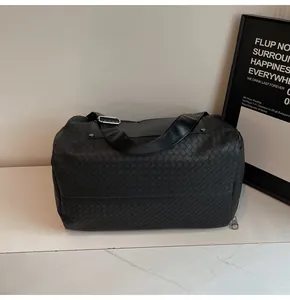 Primo piano della trama intrecciata nera su borsa da palestra multifunzionale.