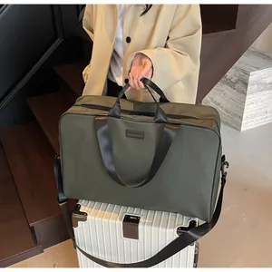 Large olive green travel duffel bag with trolley sleeve mounted on white suitcase.