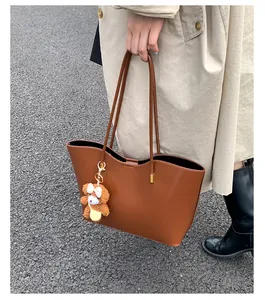 Grand sac cabas en cuir marron avec un joli pendentif ours pour l'automne-hiver.