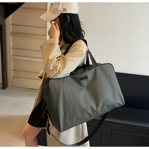 Large capacity olive green travel duffle bag carried by a model in a lifestyle setting.