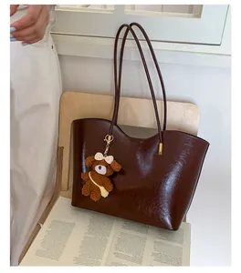 Vue détaillée du grand sac cabas marron avec un charmant ours en peluche.