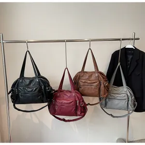 Detailed view of vintage multi-pocket PU leather tote bags in four classic colors on a rack.