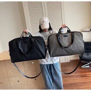 Detailed view of large capacity travel duffel bags in black and khaki held by a model