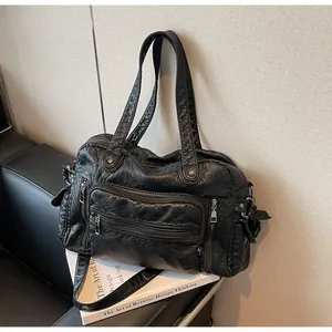 Close-up detail shot of black vintage PU leather tote bag with multiple zipper pockets