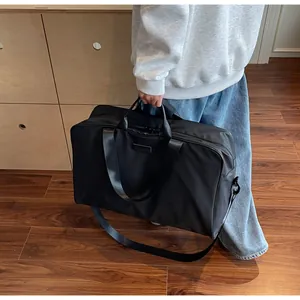 Black large capacity travel duffle bag carried by person in a lifestyle setting