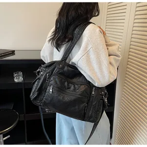 Detailed view of a black vintage PU leather tote bag with multiple zipper pockets