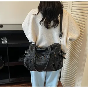 Woman carrying black vintage PU leather tote bag with multiple pockets for daily commute