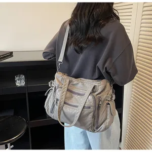 Detailed view of grey vintage PU leather tote bag with multiple pockets worn on shoulder
