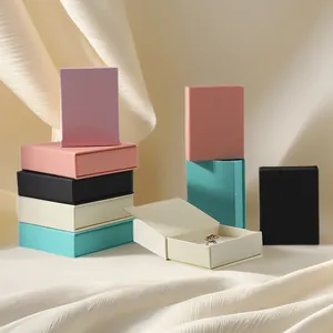 Pila de joyeros magnéticos estilo libro de colores, uno abierto mostrando un anillo