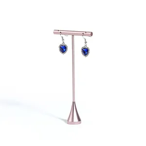 Detailansicht eines eleganten roségoldenen T-Schmuckständers mit blauen Herz-Ohrringen.