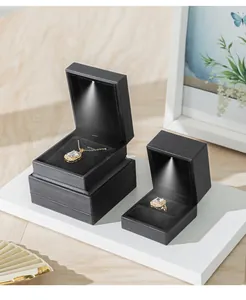 Close-up of premium black jewelry boxes with integrated LED spot lighting for rings