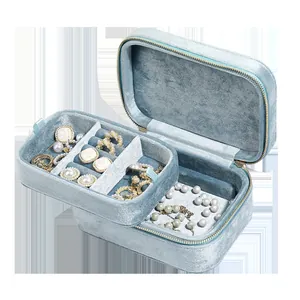 Detailed view of an open double-layer light blue velvet jewelry box with pearls