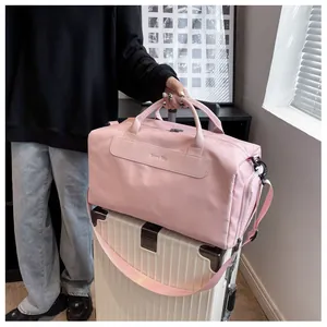 Close-up of pink travel gym bag placed on a white suitcase in a lifestyle setting