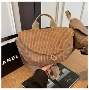 Vista detallada de bolso de lona marrón con diseño de rejilla y cierre magnético