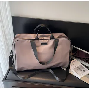 Spacious taupe travel duffle bag with sturdy black handles and adjustable shoulder strap